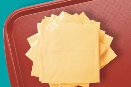 A stack of cheese slices on a cafeteria tray.