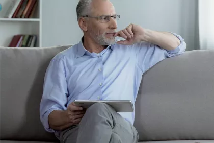 Man sitting on a couch looking out of a window