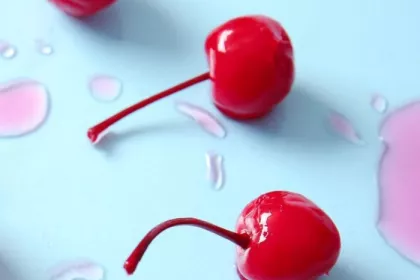 Maraschino cherries on a blue surface