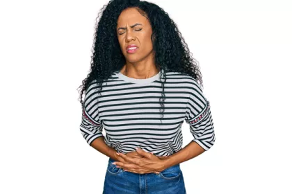 woman holding her stomach and wincing