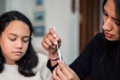 Mother following the instructions to collect a sample of the covid test result at home