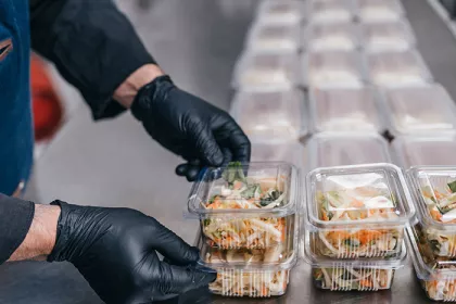 Food in disposable dishes ready for delivery. The chef prepares food in the restaurant and packs it in disposable lunch boxes.