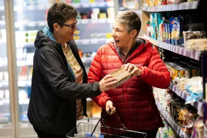 Older couple shopping together, reading food labels