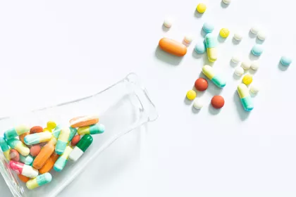 beaker spilling colorful pills