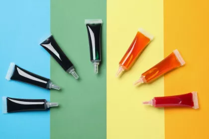 Tubes of commercial food dyes on a rainbow background