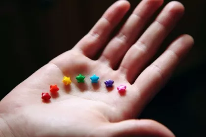 Brightly colored star-shaped sprinkles in a child's hand