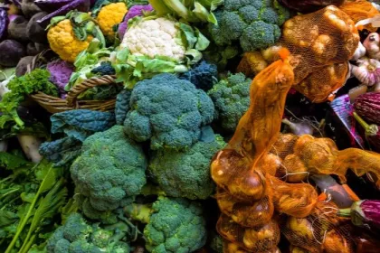 Seasonal produce at a market in October, including broccoli, eggplant, garlic, cauliflower