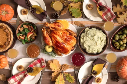 Thanksgiving meal with turkey, pecan pie, mashed potatoes, brussels sprouts, and salad