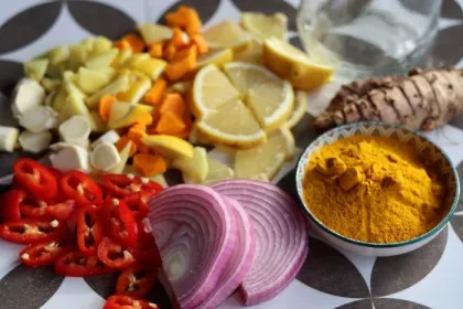 Fire cider chopped ingredients on grey tiled background. Top view photo of turmeric, ginger, pepper, garlic, onion and lemon.