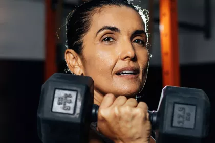 woman holding a dumbbell under her chin 