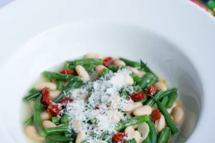 white bowl filled with beans and greens