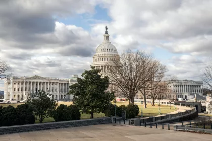 View of the Capitol Building against a cloudy sky from across the street 