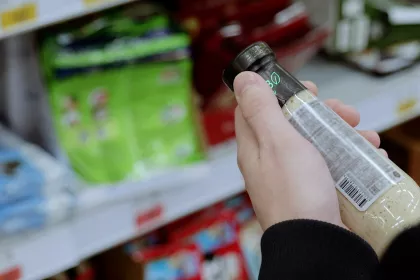 a person reading a product label in a grocery store