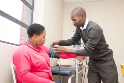 A man taking a woman's blood pressure. 