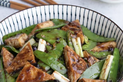 bow of tofu triangles and snow peas with scallions and garlic