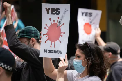A group of people holding pro-science signs and wearing masks