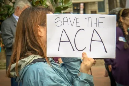 Rally in Support of the Affordable Care Act, at The White House, Washington, DC USA, carrying a sign that reads "SAVE THE ACA"