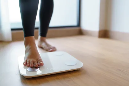 person stepping on a scale on wood floor