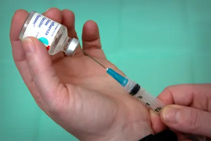 Flu vaccine being extracted from a vial