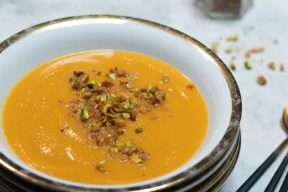 white bowl filled with butter nut soup and dukkah