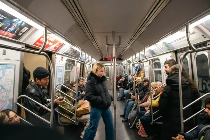 Inside a NYC subway car with prominently displayed ads