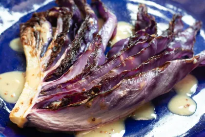 red cabbage leaf with honey mustard sauce on indigo plate