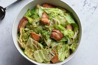 bowl filled with green cabbage and chicken stir fry on white counter