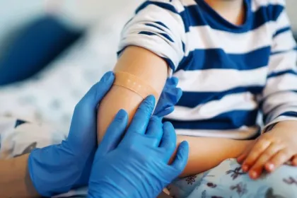 Children's doctor vaccinating little boy against common childhood diseases