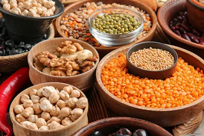 several wooden bowls fille with all different lentils and legumes