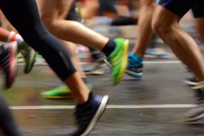 legs and feet of runners passing on a road