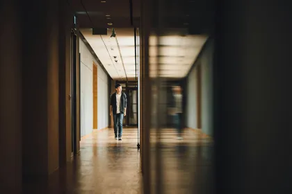 An adolescent boy walking alone down a school hallway
