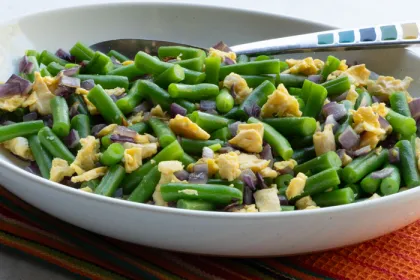 white bowl with green beans, egg and chopped onion