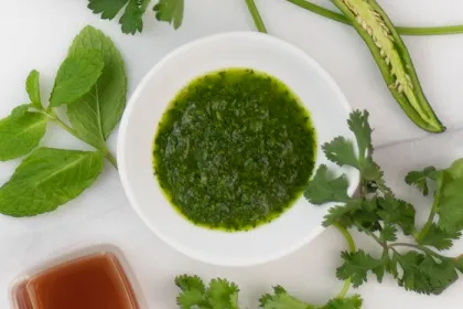 bowl of chimichurri surrounded by whole ingredients