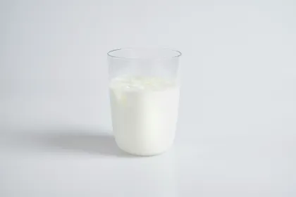 A cup of milk on a white table.