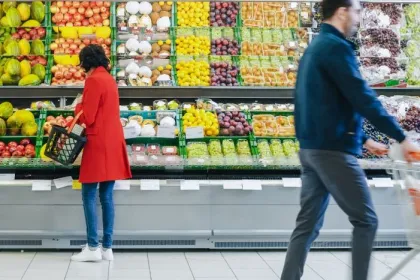 At the Supermarket: Woman Chooses Organic Fruits in the Fresh Produce Section of the Store