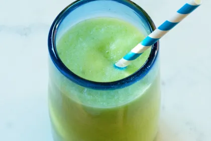 clear glass with blue rim filled with a light green drink