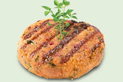 grilled plant based burger patty with green sprout coming out