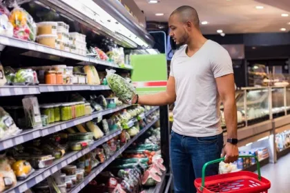 A man shops for bagged salad