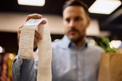 A man holds a grocery store receipt
