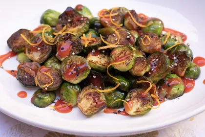 plate of Brussel sprouts halved, roasted and covered in a sauce