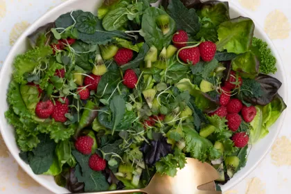large plate filled with salad greens and berries