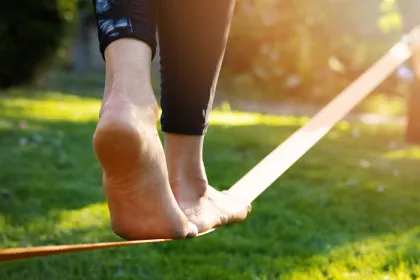 woman's feet walking on a tightrope low to the ground in a park