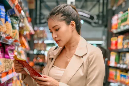 woman in grocery store looking at package of food