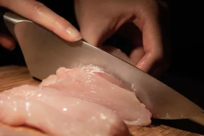 cutting raw chicken