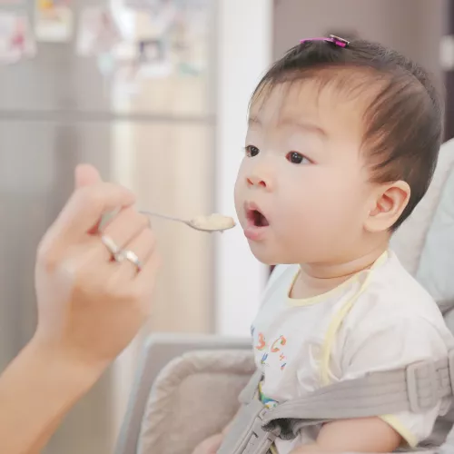 Baby being fed baby food