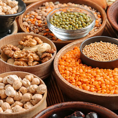 several wooden bowls fille with all different lentils and legumes