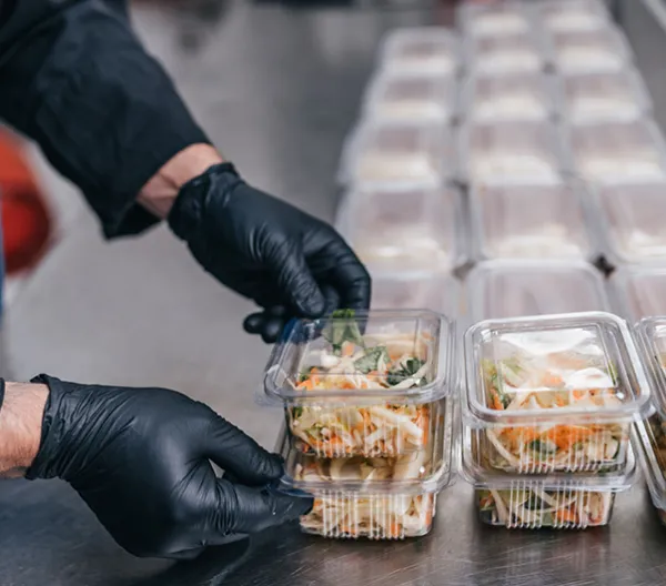 Food in disposable dishes ready for delivery. The chef prepares food in the restaurant and packs it in disposable lunch boxes.