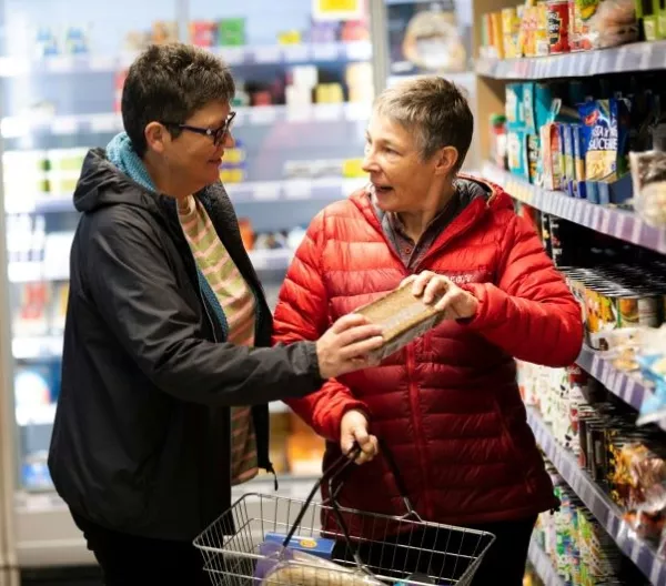 Older couple shopping together, reading food labels