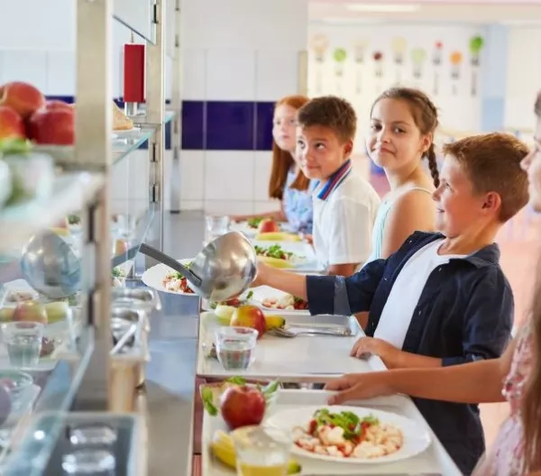 Children wait in line for a healthy school meal. In California, synthetic food dyes could soon be banned from foods sold in schools