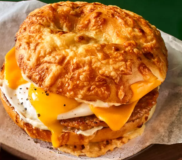 panera's asiago sausage & egg sandwich on a green background